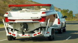 A SUV pulls a boat on a trailer.